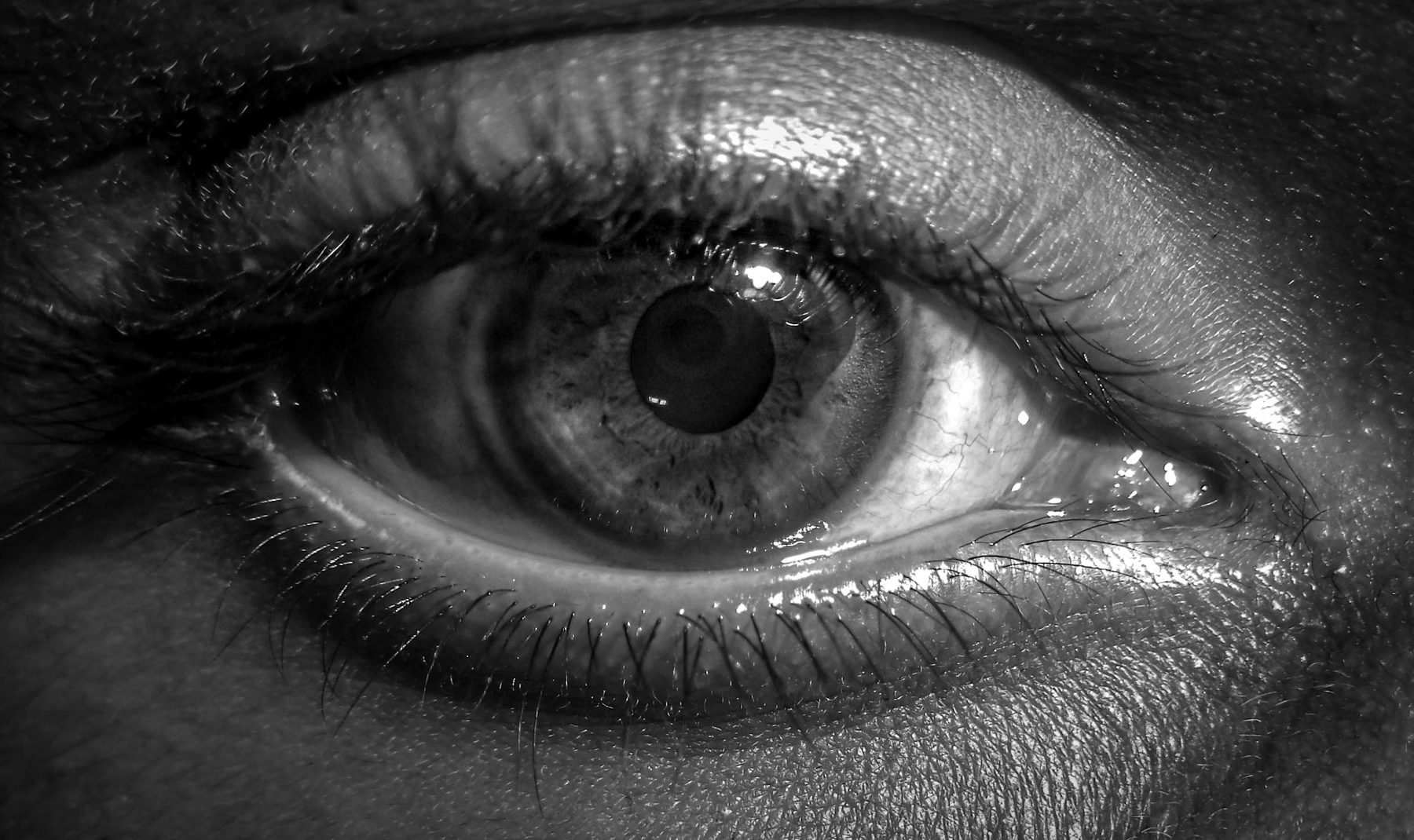 An eye seen through shattered glass
