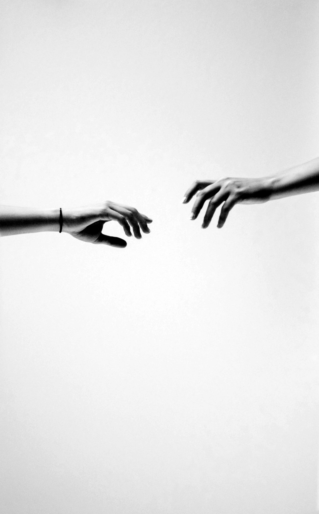 Two hands reaching towards each other
