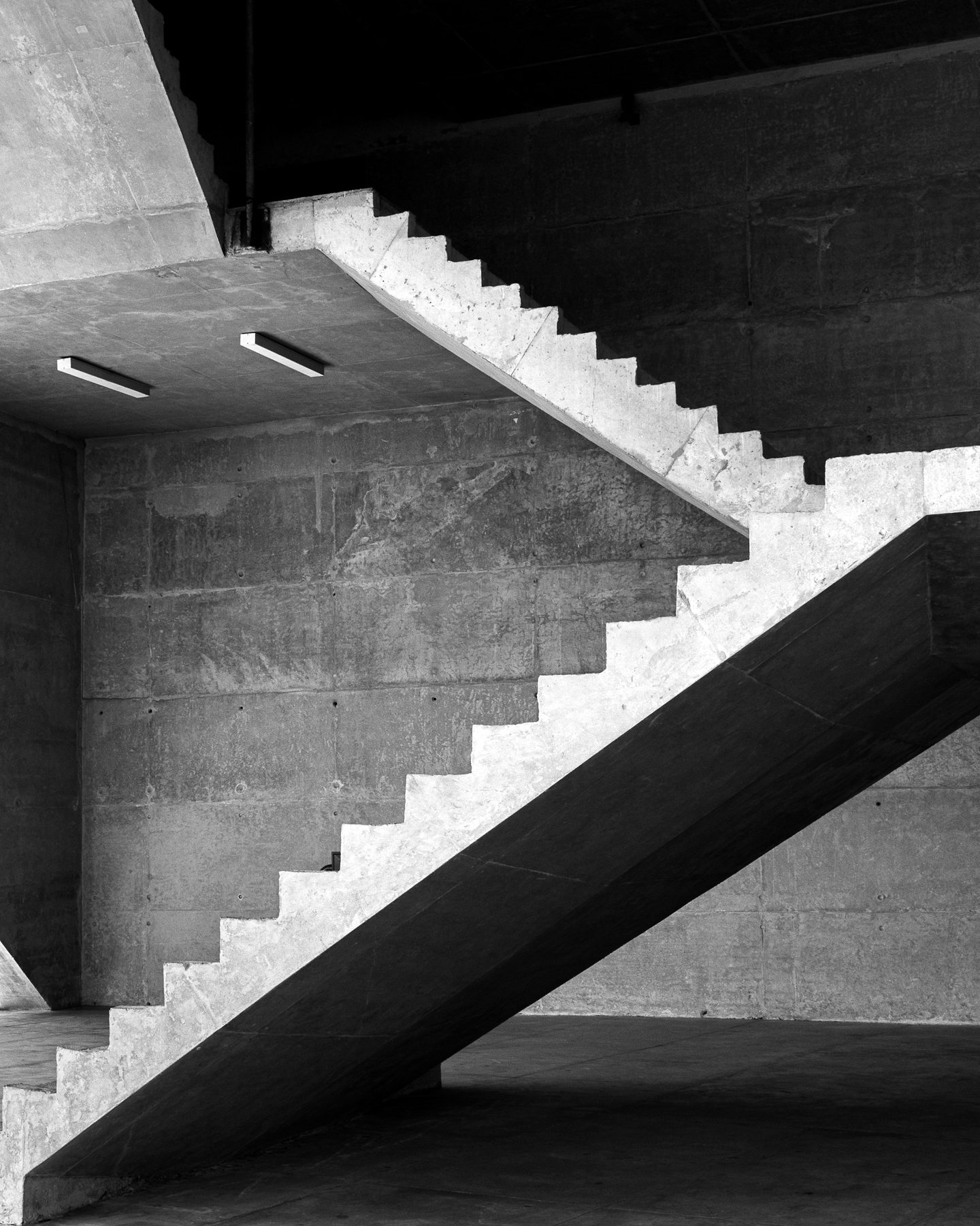 A staircase climbing a sunlit wall